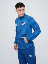 Campera deportiva Umbro del Club Nacional de Football, modelo Grok, en color bordó con diseño estampado sutil. Cuenta con cierre frontal completo, cuello alto y bolsillos laterales.