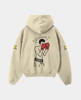 Canguro con capucha color beige, de corte regular, con estampado estilo pixel art en la espalda que representa a un boxeador con guantes rojos y estrellas alrededor. Presenta detalles de estrellas estampadas en las mangas.