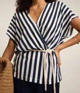 Blusa de viscolino a rayas verticales azul marino y blanco, con escote en V cruzado, mangas cortas y cinturón de cuerda en la cintura.