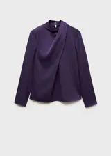 Blusa de tejido satinado color violeta, con cuello alto drapeado y mangas largas.