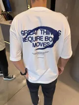 Remera de algodón pesado con corte oversize, color blanco, con estampa gráfica en azul en la espalda que incluye texto y un círculo irregular.
