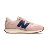 Championes urbanos New Balance modelo WS237GC, de mujer. Diseño en tonos rosa pastel con detalles en azul marino y suela color caramelo.