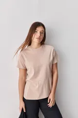 Remera de manga corta color beige, con cuello redondo y costura diagonal decorativa en la parte inferior.