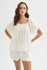 Blusa holgada de lyocell color blanco, con diseño plisado, escote cuadrado y mangas cortas abullonadas.