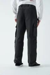 Pantalón cargo de canvas color marrón, con tiro medio, múltiples bolsillos laterales y traseros, y cierre frontal con botón y cremallera.