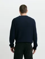 Sweater de punto inglés con escote redondo y mangas largas. Presenta cuello y puños terminados en punto canalé.