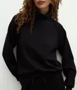Buzo de cuello alto estructurado, confeccionado en tejido modal acanalado color marrón. Presenta un corte regular, mangas largas con puños ajustados y diseño minimalista.