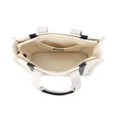 Bolso tipo tote bag color crudo, con asas de mano y detalles en símil cuero color marrón. Tiene estampado vertical con la inscripción "Lincoln's".