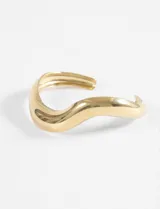 Pulsera rígida dorada de acero quirúrgico hipoalergénico con diseño ondulado wavy.