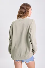 Sudadera de manga larga color beige claro con cuello redondo y mangas raglán.