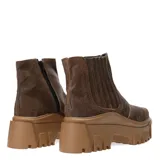 Botas tipo chelsea de cuero negro con caña media y paneles elásticos laterales. Presentan una suela track de plataforma alta con diseño dentado.