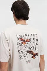 Remera de manga corta color beige, con estampado en la espalda de dos águilas volando y la palabra "UNLIMITED" repetida en un patrón ondulado. Incluye la frase "BRING HOPE TO LIFE AND LIGHT TO THE WORLD Mistral" en la parte inferior.