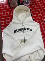 Buzo con cierre frontal completo, capucha amplia y bolsillos tipo canguro. Presenta estampado gráfico en el pecho con la marca IttaiStars y diseño de corte holgado.