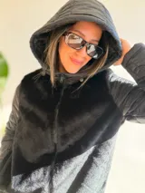 Campera con cuerpo de piel sintética tipo teddy y mangas acolchadas. Presenta cierre frontal, capucha y diseño de corte recto.