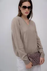 Sweater color beige de cashmere con escote en V y mangas largas.