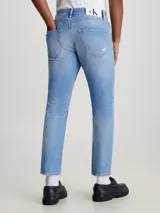 Pantalón de jean celeste con roturas, de corte recto y tiro medio.