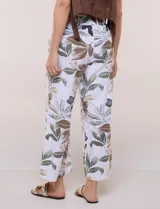 Pantalón crop de lino y rayón, con diseño wide leg de corte holgado, estampado tropical de hojas en tonos verde, azul y marrón sobre fondo blanco. Cuenta con pretina trasera elastizada y bolsillos delanteros.