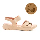 Sandalias bajas de cuero color beige, con ajuste mediante correa elástica en el tobillo y tira ancha con velcro en el empeine.