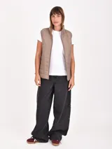 Chaleco acolchado de diseño matelasse, color beige, con cuello alto, cierre frontal y bolsillos laterales.