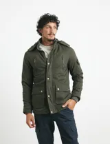 Campera de abrigo color verde militar, con capucha desmontable forrada, cierre frontal con cremallera y botones a presión. Cuenta con múltiples bolsillos: dos en el pecho con cierre, dos en la cintura con botones y un bolsillo en la manga. El interior está forrado para mayor calidez.