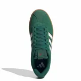 Championes Adidas modelo VL Court 3.0, de color verde con diseño clásico. Presenta la parte superior en gamuza con las icónicas tres tiras laterales en blanco con bordes oscuros. Cuenta con suela de caucho color caramelo y cierre mediante cordones al tono.