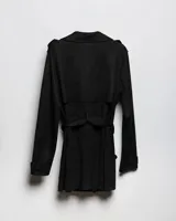 Campera tipo trench negra a la cadera, con solapa cruzada, doble botonadura frontal, hombreras y bolsillos delanteros con solapa.