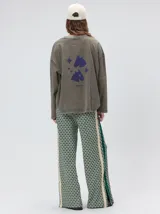 Remera de manga larga con calce holgado y cuello a la base. Presenta un diseño minimalista con una pequeña estrella estampada en el pecho y gráficos inspirados en el universo tora en la parte posterior. Confeccionada en algodón con acabado tipo gastado.