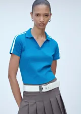 Polo de manga corta color azul, con cuello polo y detalle de rayas blancas en contraste sobre los hombros. Presenta un diseño entallado y recto.
