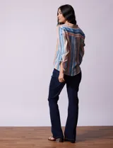 Blusa celeste con estampado de flores grises, de gasa, con cuello con solapa y escote en V, abertura central con botones, bolsillo aplicado y terminación anudada.