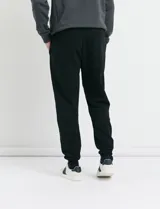 Pantalón jogging de tejido circular con cintura elástica y cordón ajustable. Presenta puños elastizados en el ruedo y bolsillos laterales.
