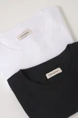 Pack de dos remeras de manga corta en jersey de algodón, una blanca y una gris melange, con cuello redondo y calce clásico.