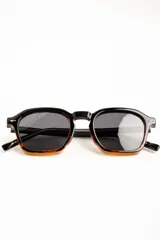 Lentes de sol polarizados con armazón negro de diseño geométrico y lentes oscuros.