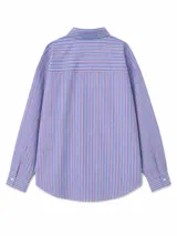 Camisa de corte clásico y diseño holgado, color celeste, con cuello camisero, cierre frontal de botones y mangas largas con puños abotonados. Presenta un ruedo redondeado.