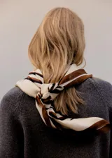Pañuelo de seda con diseño de rayas horizontales en tonos crema, marrón y negro.