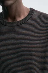 Jersey de corte relajado con cuello redondo y manga larga, confeccionado en tejido jacquard con diseño de rayas horizontales finas.