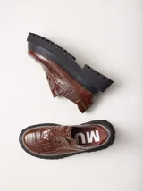 Mocasines color marrón con estampado de cocodrilo y plataforma negra con suela dentada.