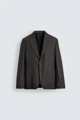 Blazer de corte relajado confeccionada en tejido de lana. Presenta cuello con solapa de muesca, cierre frontal de un botón, bolsillos plastrón en la cadera y manga larga con puños abotonados.