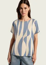 Blusa de manga corta con estampado geométrico en tonos celeste y beige, cuello redondo y corte holgado.