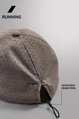 Gorra deportiva de tejido técnico ligero en color azul marino, con visera corta y paneles laterales perforados para mayor ventilación. Presenta logos bordados a tono en el frente.