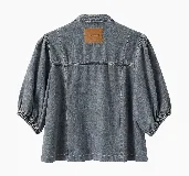 Chaqueta de denim azul con diseño abierto, mangas abullonadas tres cuartos con puños fruncidos y bolsillos frontales aplicados.