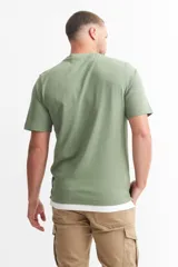Remera verde militar de algodón, con cuello redondo y estampado con texto en el pecho.