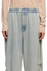 Pantalón jogger de denim celeste claro, confeccionado en mezcla de lyocell y algodón, con tiro bajo, cintura elástica y bajos fruncidos con tiras ajustables.