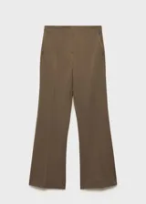 Pantalon de vestir de tiro medio con corte flare y diseño largo. Cuenta con dos bolsillos laterales y cierre frontal con cremallera, botón y ganchos ocultos bajo tapeta.