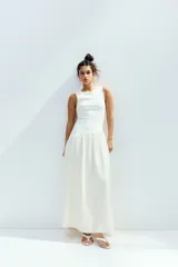 Vestido midi blanco sin mangas con cuello redondo, cuerpo entallado en punto acanalado de algodón y falda amplia con costura fruncida en diagonal.