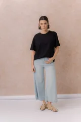 Pantalón jean tiro alto de color celeste claro, con corte wide leg y largo cropped. Presenta bolsillos funcionales y terminación de ruedo ancho.