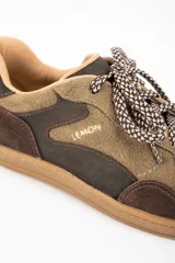 Zapatilla de cuero combinada en tonos marrones y visón, con diseño de paneles superpuestos, cordones jaspeados y suela de goma color caramelo.
