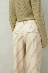 Pantalón ancho de algodón con estampado botánico en tonos verde y beige, corte recto y bolsillos de parche.