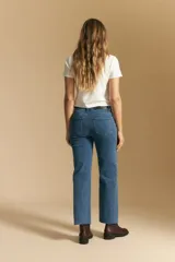 Jean de corte recto y tiro medio, confeccionado en denim elastizado de color negro. Presenta un diseño clásico con cierre de botón y cremallera, bolsillos laterales y traseros, y ruedo con terminación deshilachada.