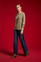 Sweater acrílico en tono natural, de corte holgado, con cuello a la base decorado con sutiles volados, mangas 3/4 y diseño tejido con motivos geométricos calados en el frente.