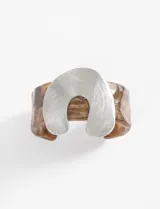Pulsera tipo cuff de acrílico con efecto carey marrón, con aplique metálico plateado de forma ondulada (wavy) en la parte superior.